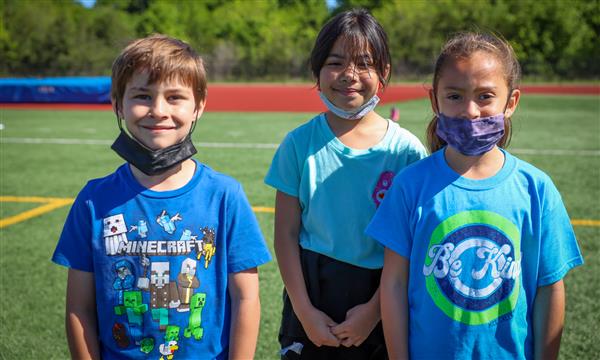 Three students smile